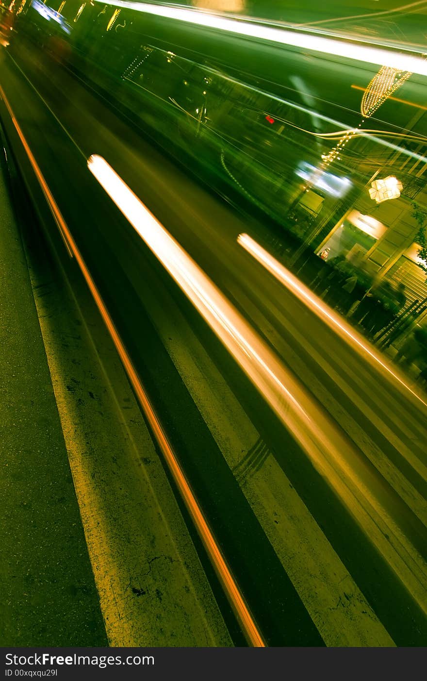 Blurred bus through zebra crossing, green toned.