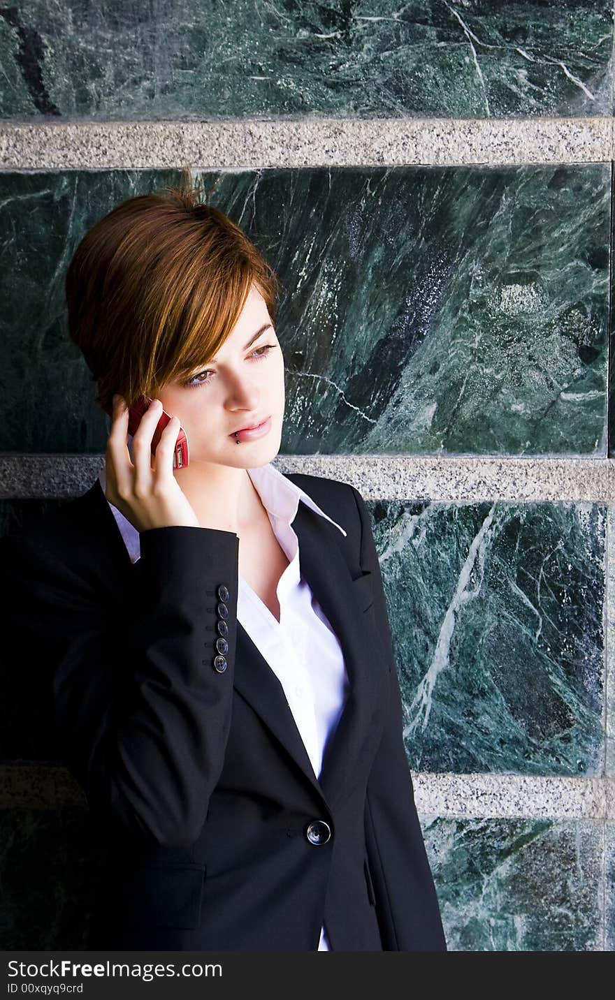 Beautiful businesswoman at phone over marble background.