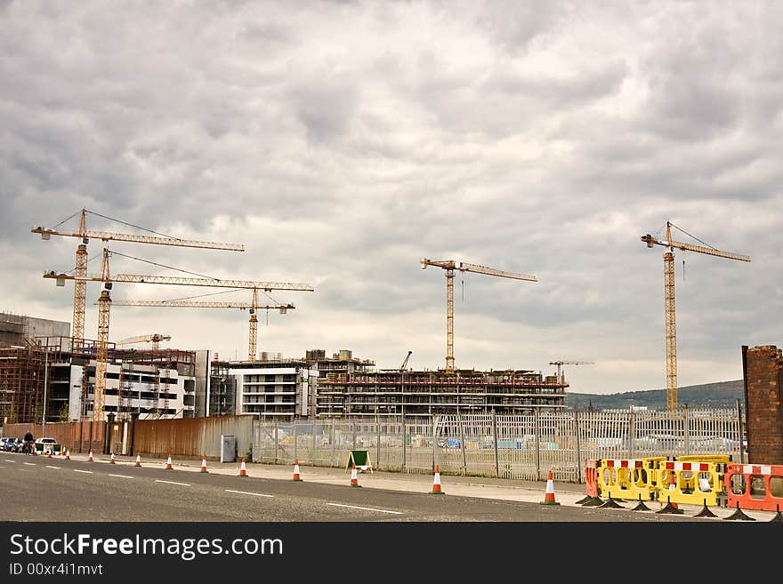 Busy construction site with cranes seen from afar. Busy construction site with cranes seen from afar