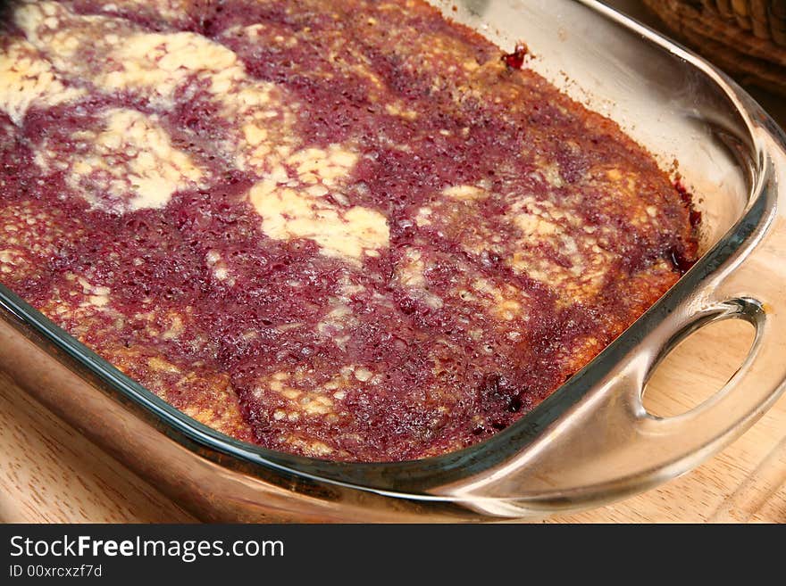 Dark cherry bread pudding close up in baking dish.