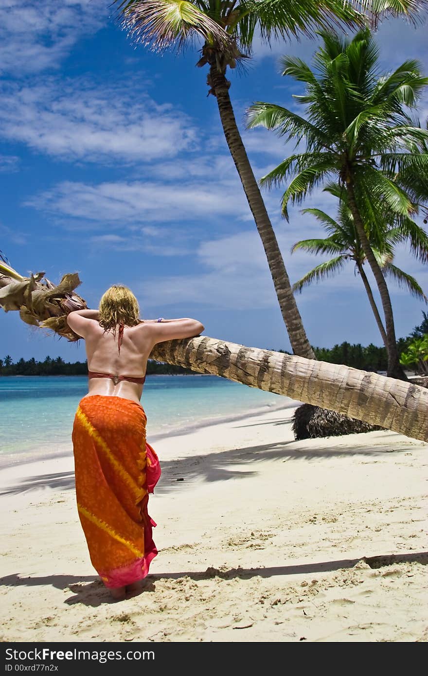 Girl and palm tree on the Bavaro Beach, Dominican republic