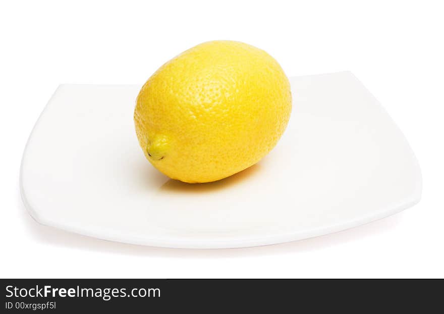 Yellow lemon on white ceramic plate, isolated, with clipping path