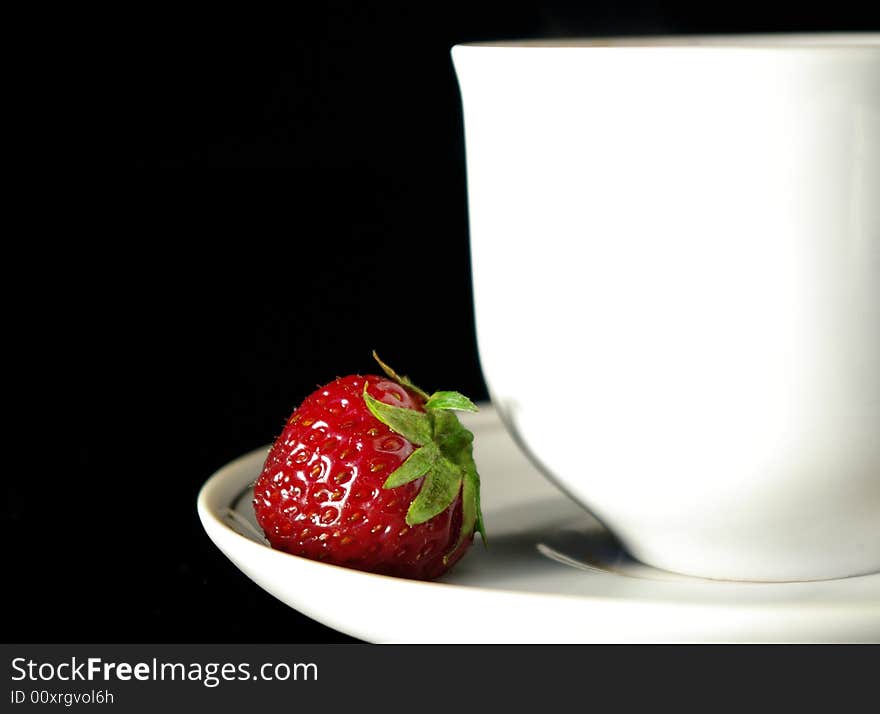 Cup of coffee and strawberry on a black background