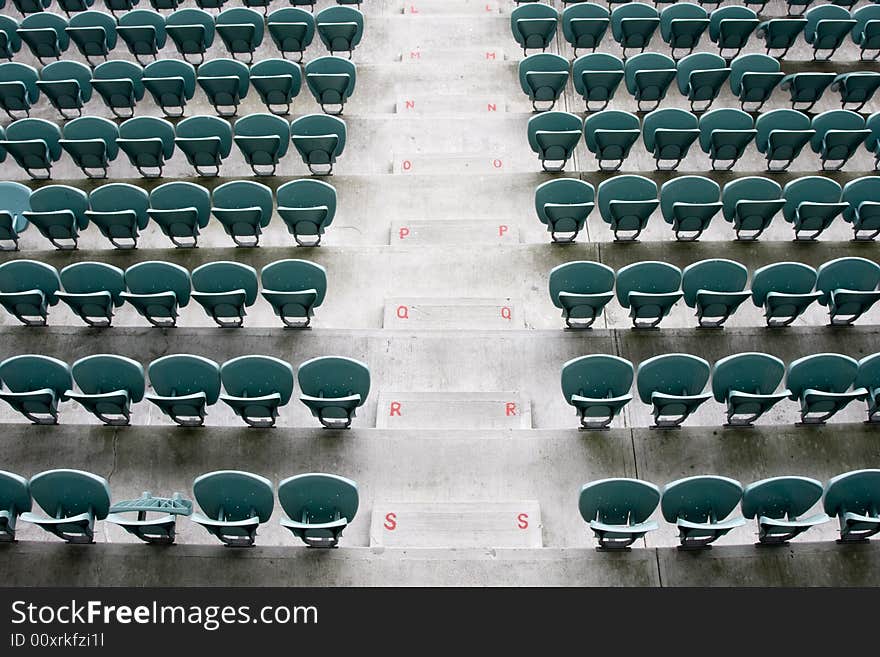 Empty Seating at Sports Stadium with Green Chairs