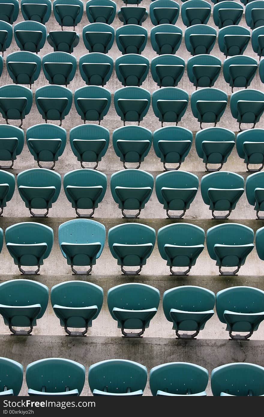 Empty Seating at Sports Stadium with Green Chairs