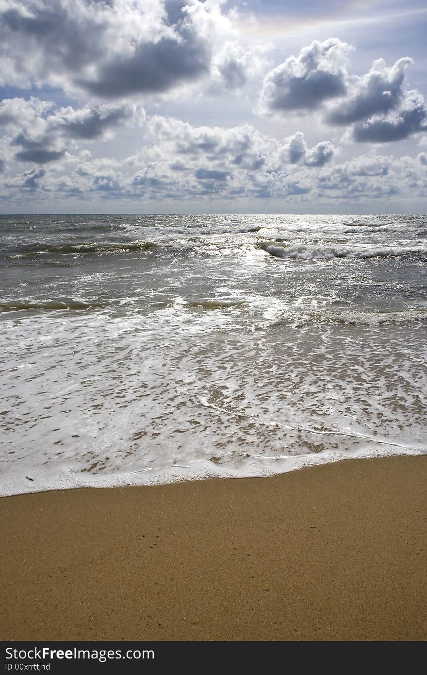 Beach seascape with puffy clouds