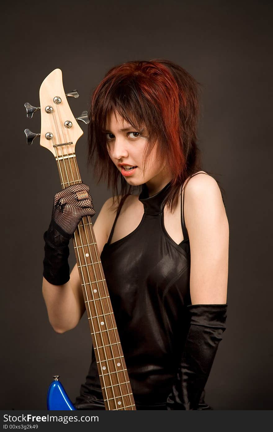 Beautiful girl with bass guitar isolated in studio