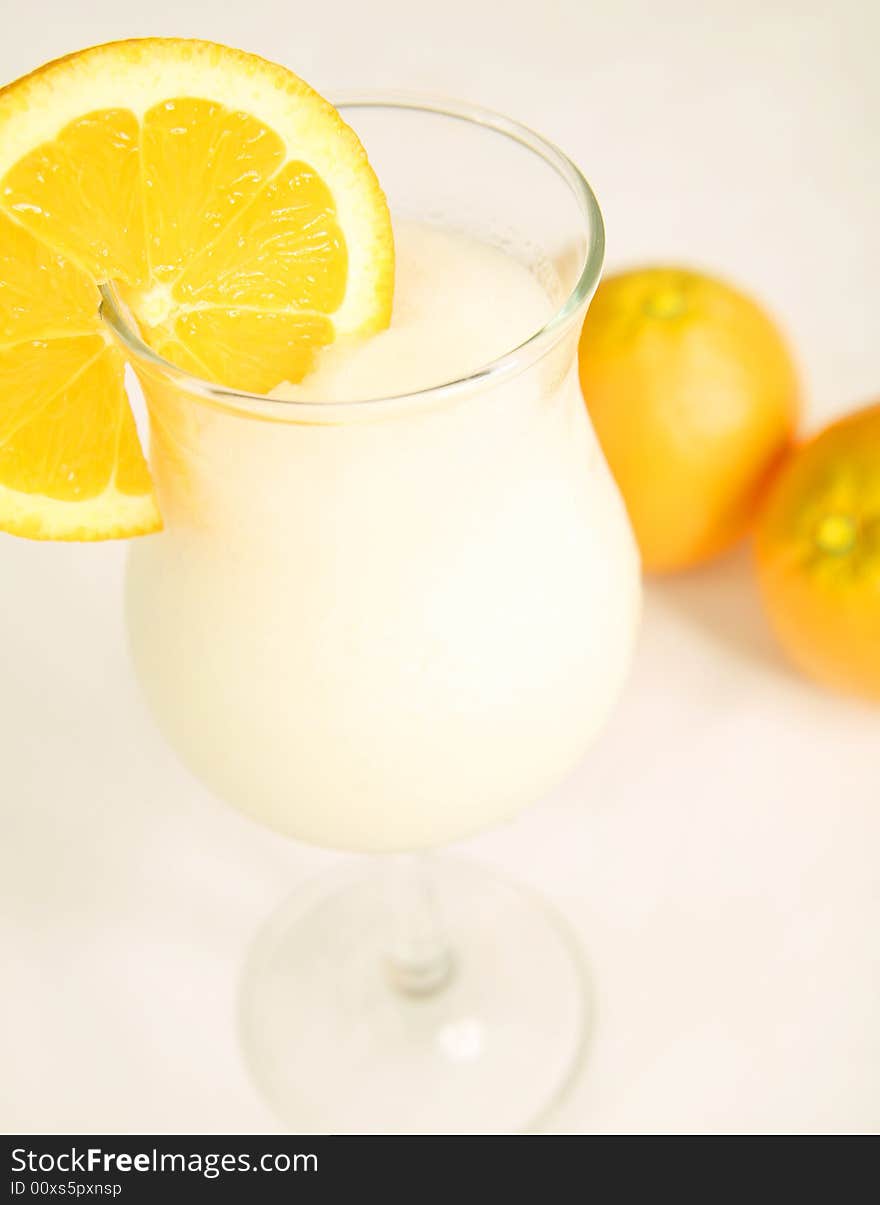 White pina colada with sliced orange, shot on white table cloth. White pina colada with sliced orange, shot on white table cloth