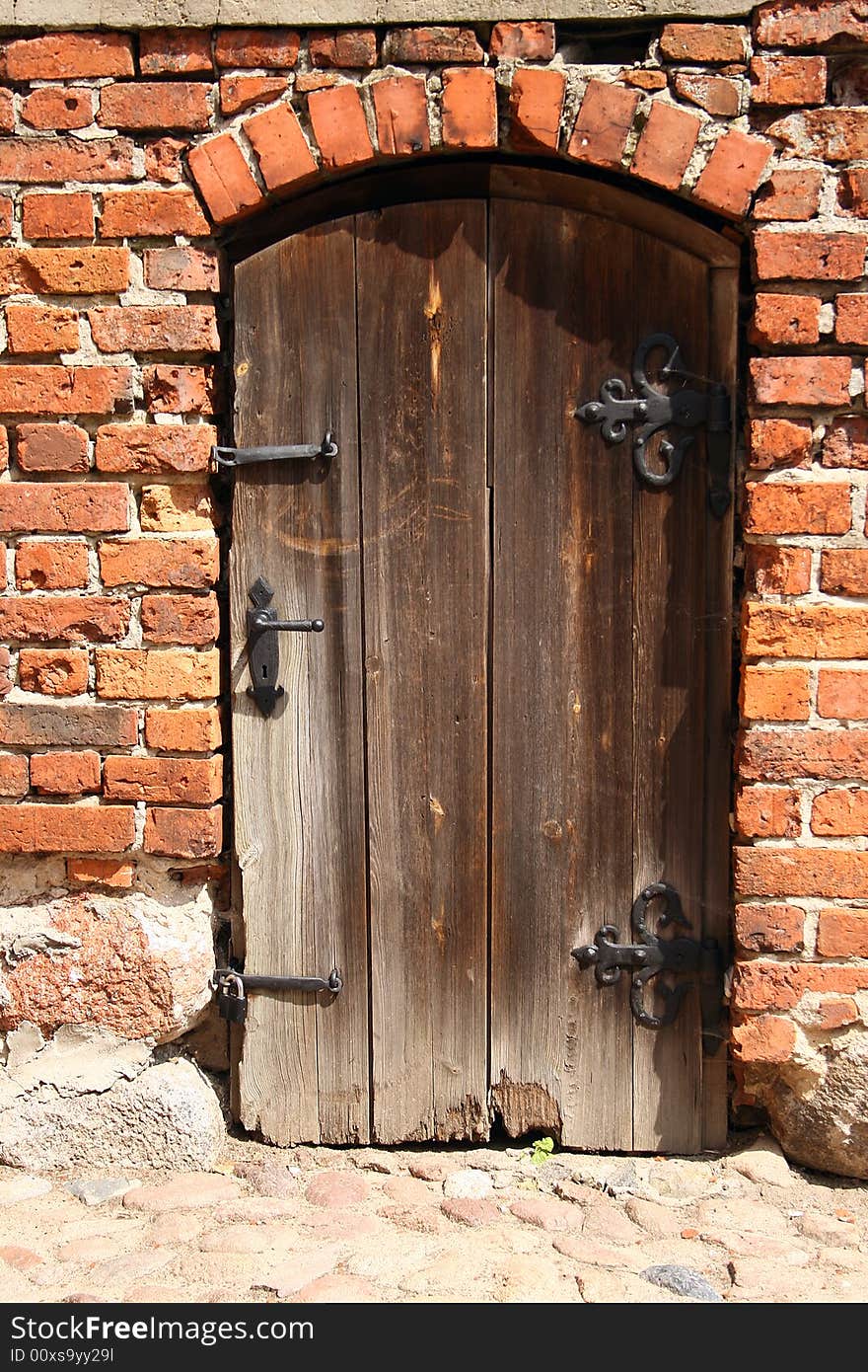 An old, rotten door in a brick wall