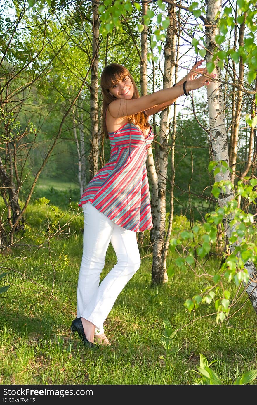 Happy young adult woman standing in birchwood. Happy young adult woman standing in birchwood