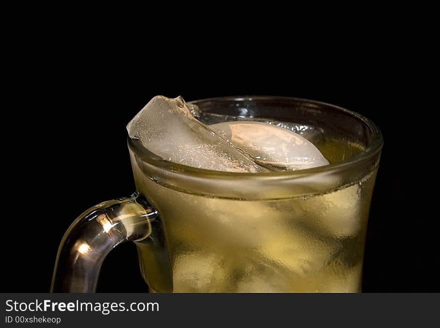 Close-up of iced green tea with focus on the ice at the top of the frosty glass.  Black background. Close-up of iced green tea with focus on the ice at the top of the frosty glass.  Black background.