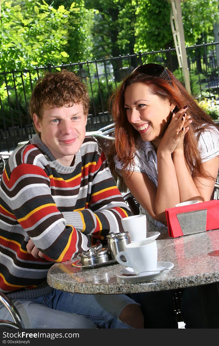 Young couple drinking coffee in open-air cafe. Young couple drinking coffee in open-air cafe