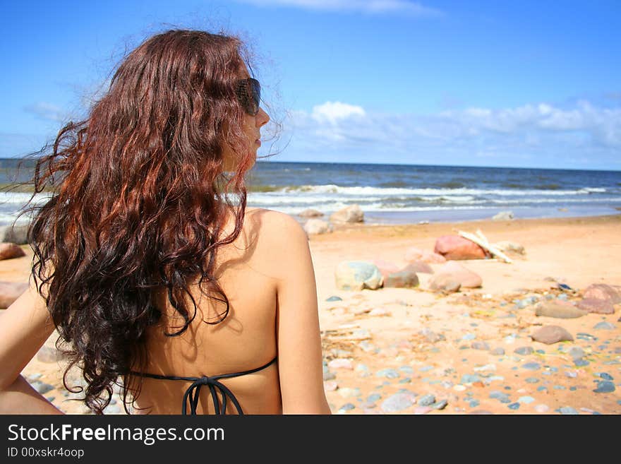 Young girl with long hair near the blue sea. Young girl with long hair near the blue sea