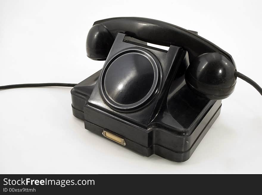 Old-fashioned black telephone receiver with cord on white background. Old-fashioned black telephone receiver with cord on white background