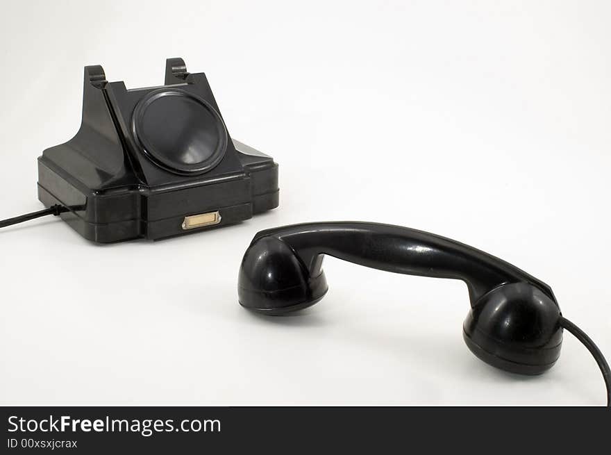 The old telephone of black colour on a white background. The old telephone of black colour on a white background.