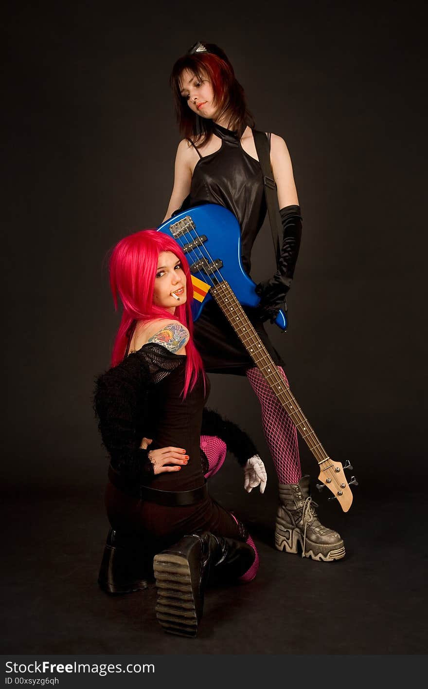 Two girls with guitar smoking, isolated in studio. Two girls with guitar smoking, isolated in studio