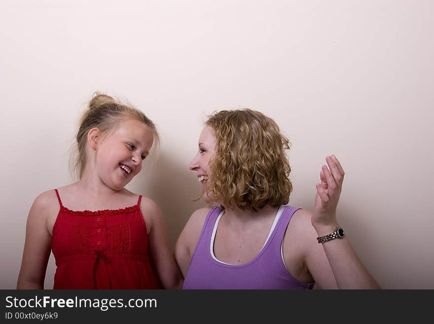 A young woman and young girl laughing and playing. A young woman and young girl laughing and playing