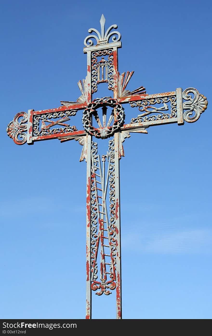 Old forged iron cross photographed in France. The blue paint is peeling. Old forged iron cross photographed in France. The blue paint is peeling.