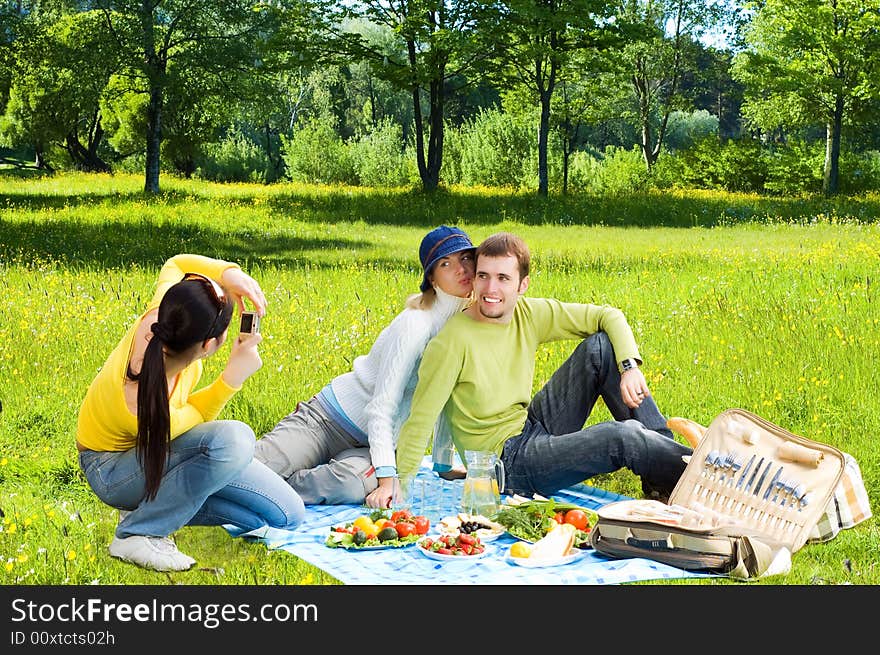 Three friends at picnic making a photos