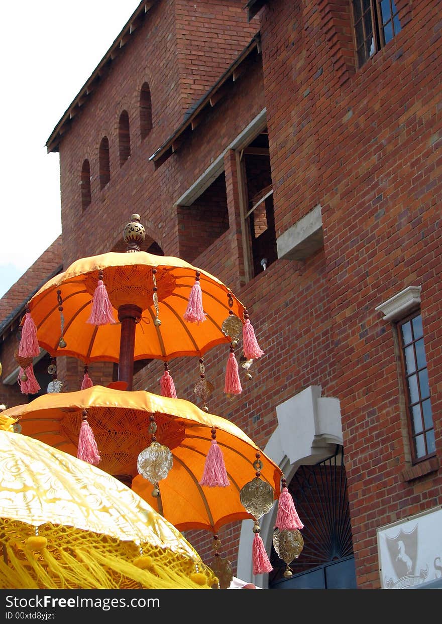 Eastern Umbrella's against a red brick building.