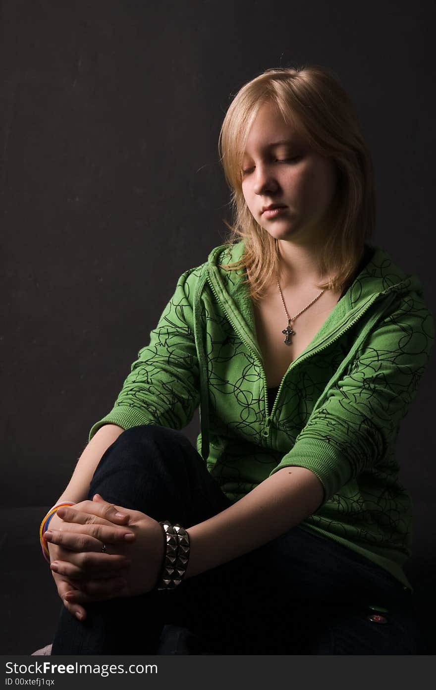 The young girl in green clothes on a black background. The young girl in green clothes on a black background.