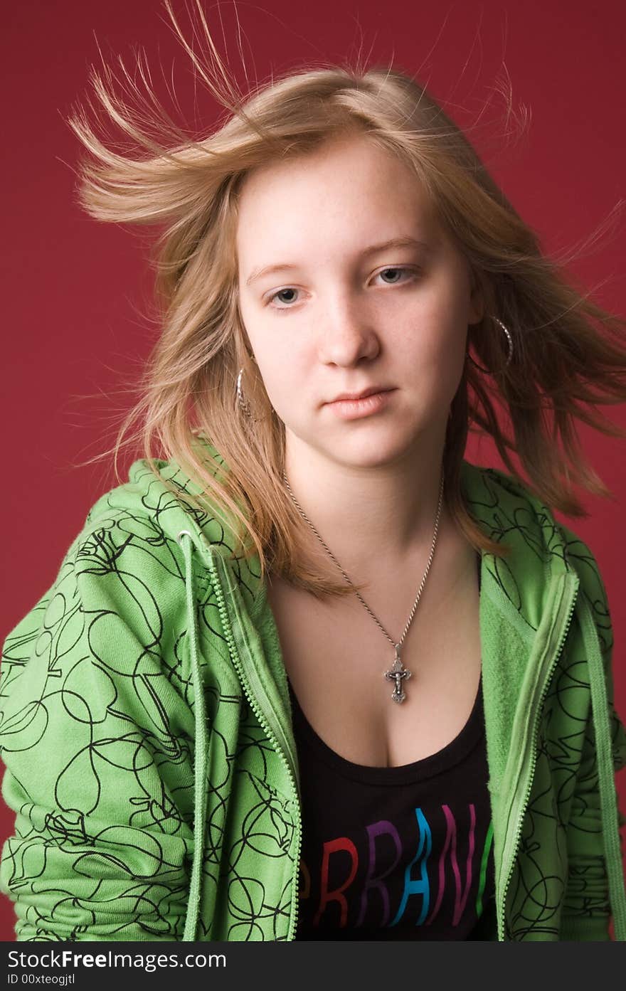 The young girl in green clothes on a red background. The young girl in green clothes on a red background.