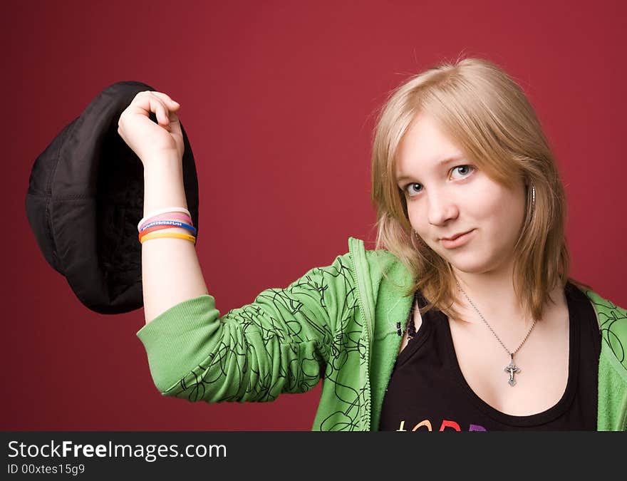 The young girl in green clothes on a red background. The young girl in green clothes on a red background.