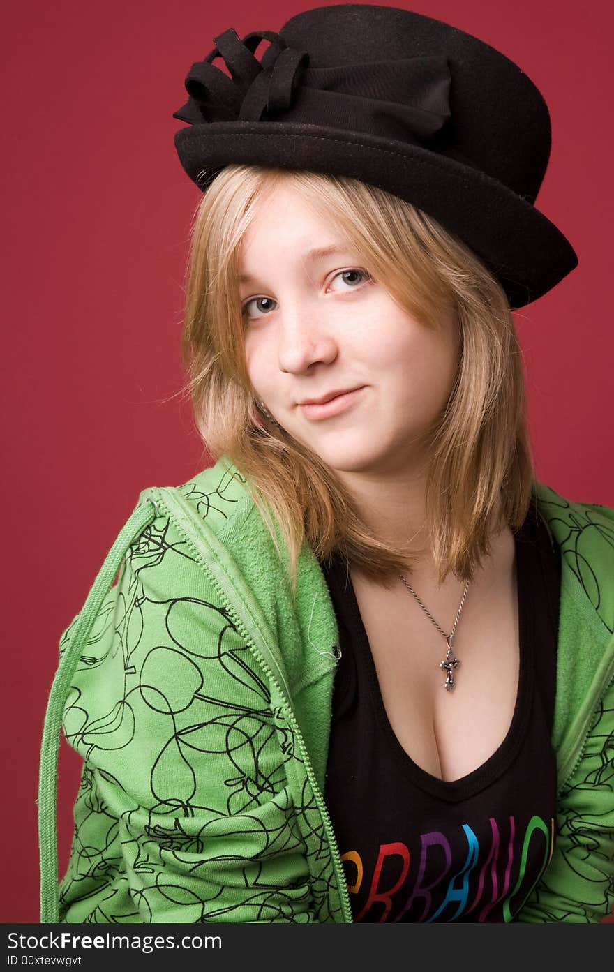 The young girl in green clothes on a red background. The young girl in green clothes on a red background.