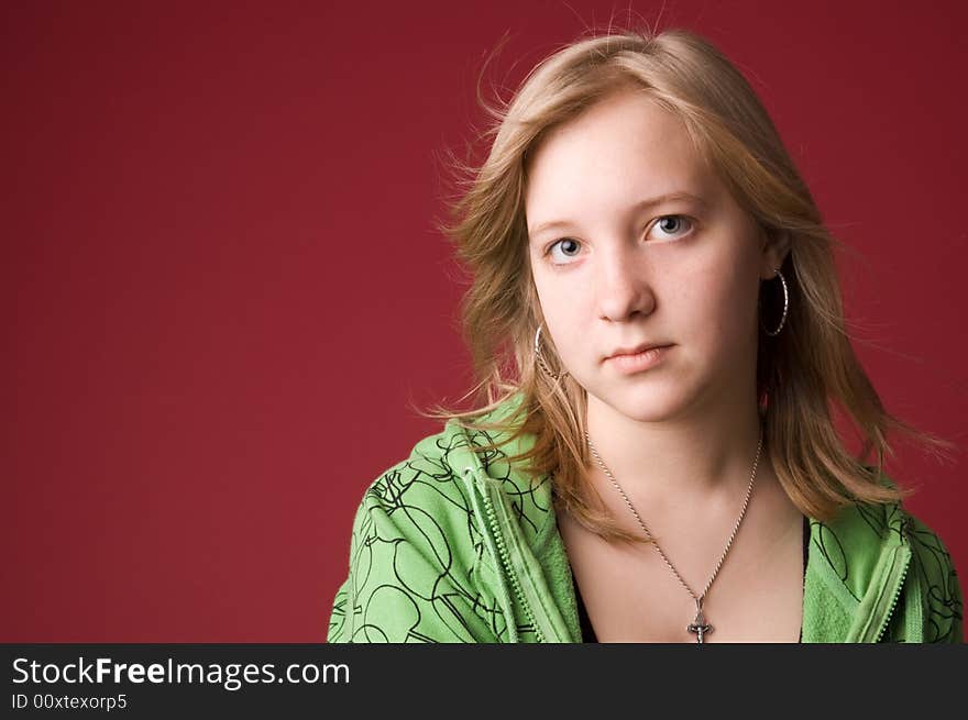 The young girl in green clothes on a red background. The young girl in green clothes on a red background.