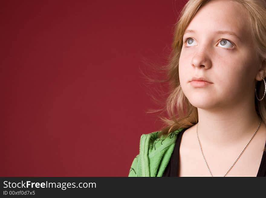 The young girl in green clothes on a red background. The young girl in green clothes on a red background.