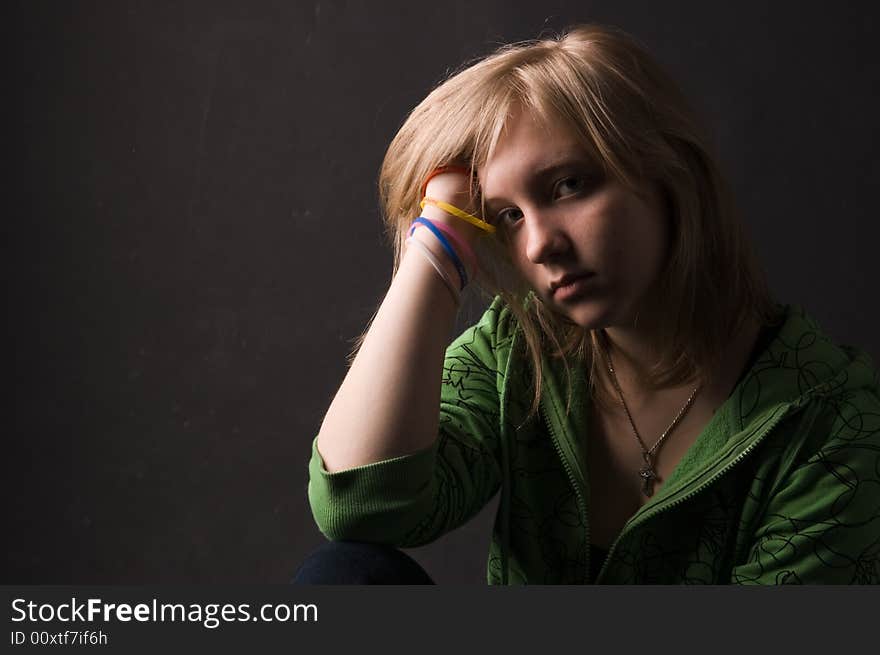 The young girl in green clothes on a black background. The young girl in green clothes on a black background.