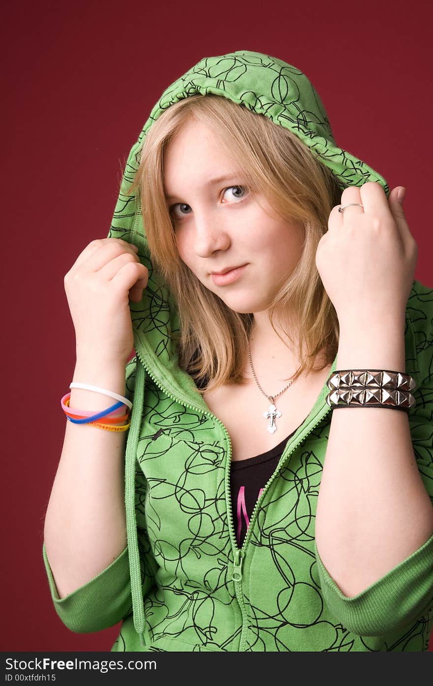 The young girl in green clothes on a red background. The young girl in green clothes on a red background.