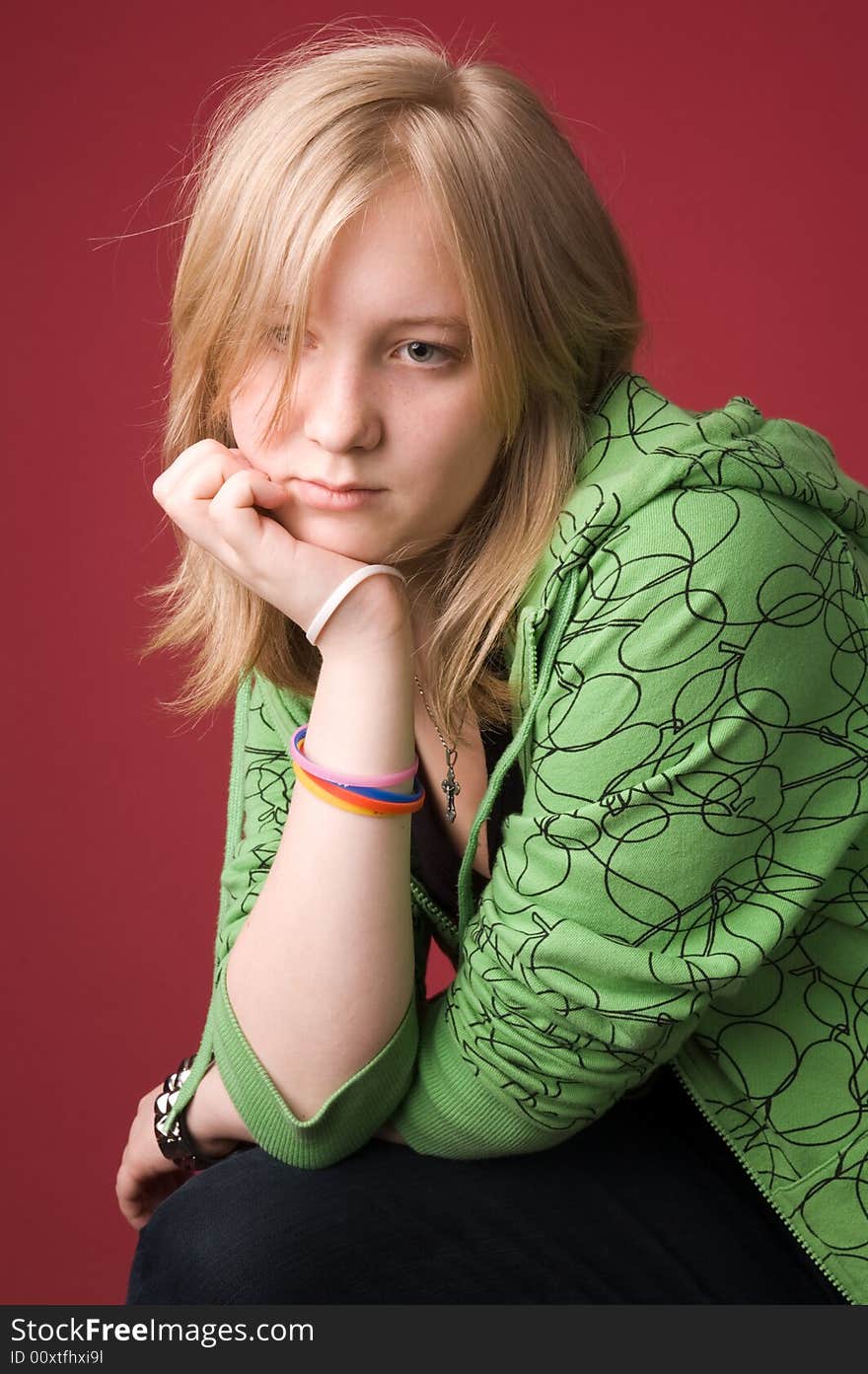 The young girl in green clothes on a red background. The young girl in green clothes on a red background.