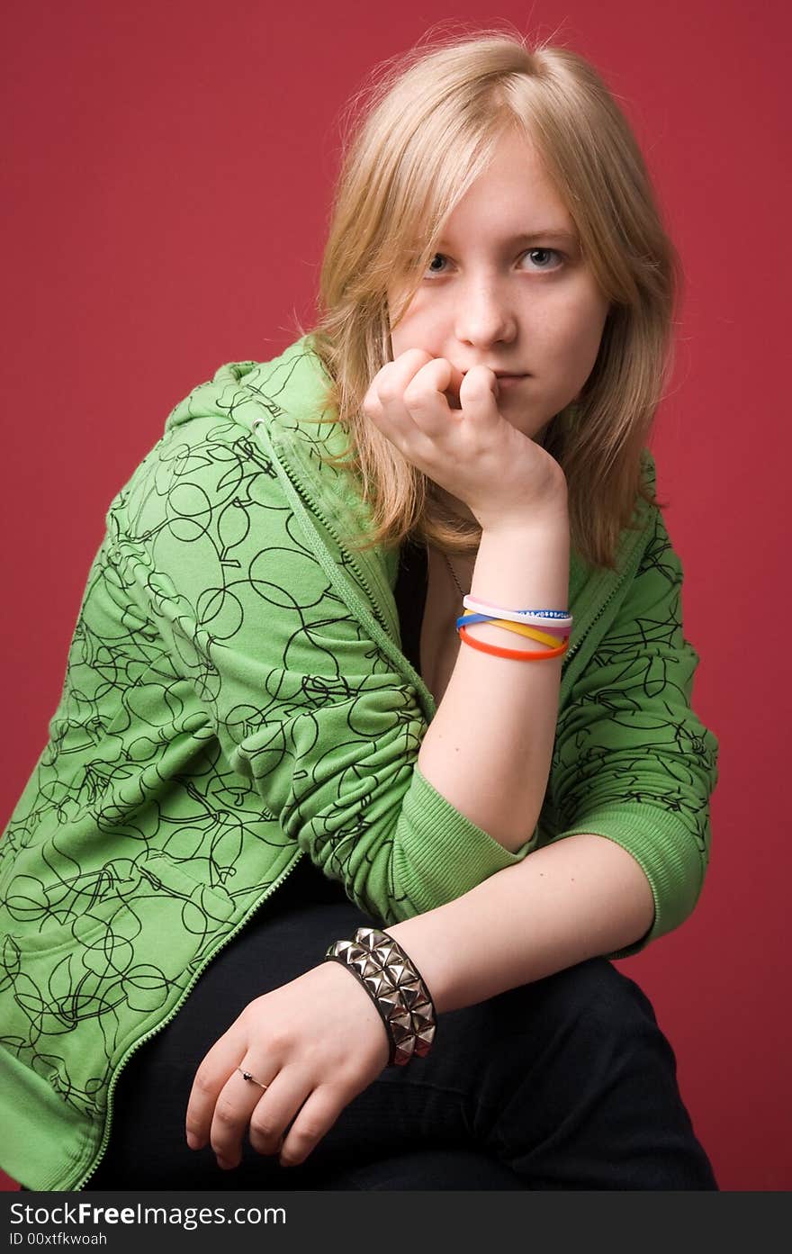 The young girl in green clothes on a red background. The young girl in green clothes on a red background.