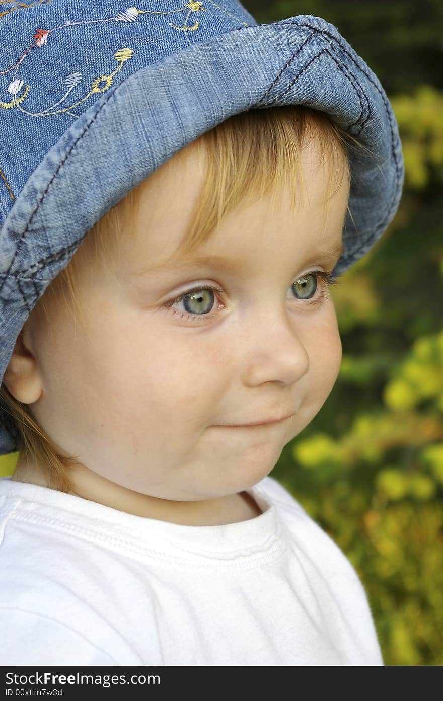 The small beautiful girl sits on a grass and smiles. The small beautiful girl sits on a grass and smiles