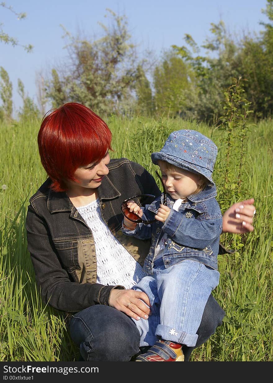 The little girl and her mum on a grass. The little girl and her mum on a grass