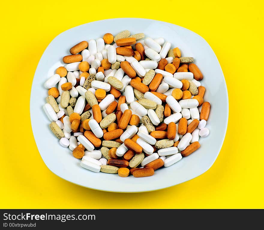 A view with some drugs and vitamins in a plate. A view with some drugs and vitamins in a plate