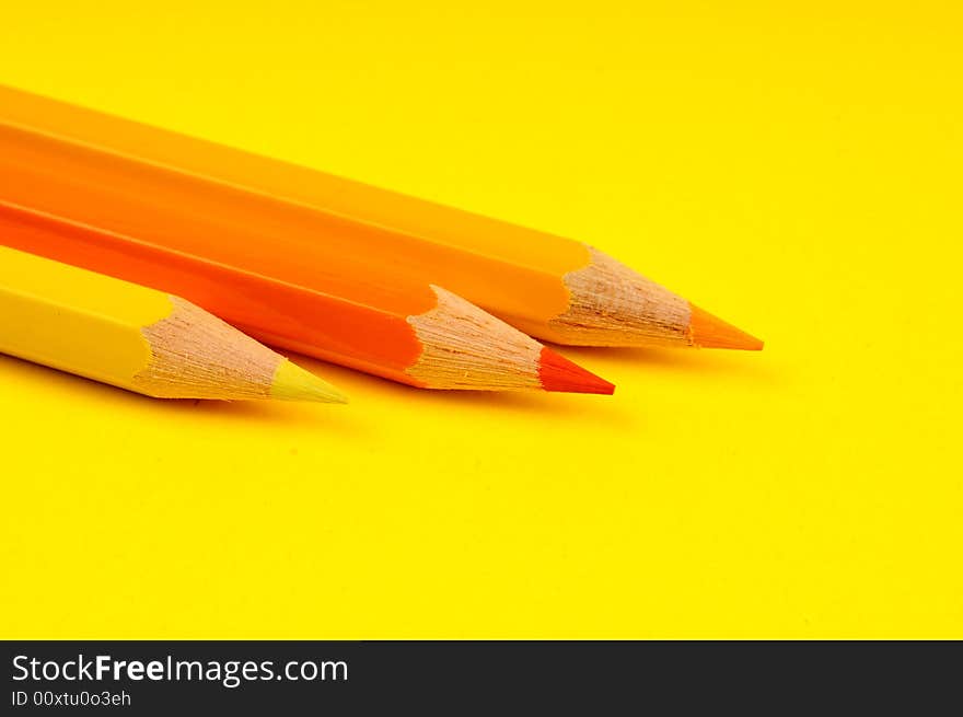 Thick colored pencils against a yellow background