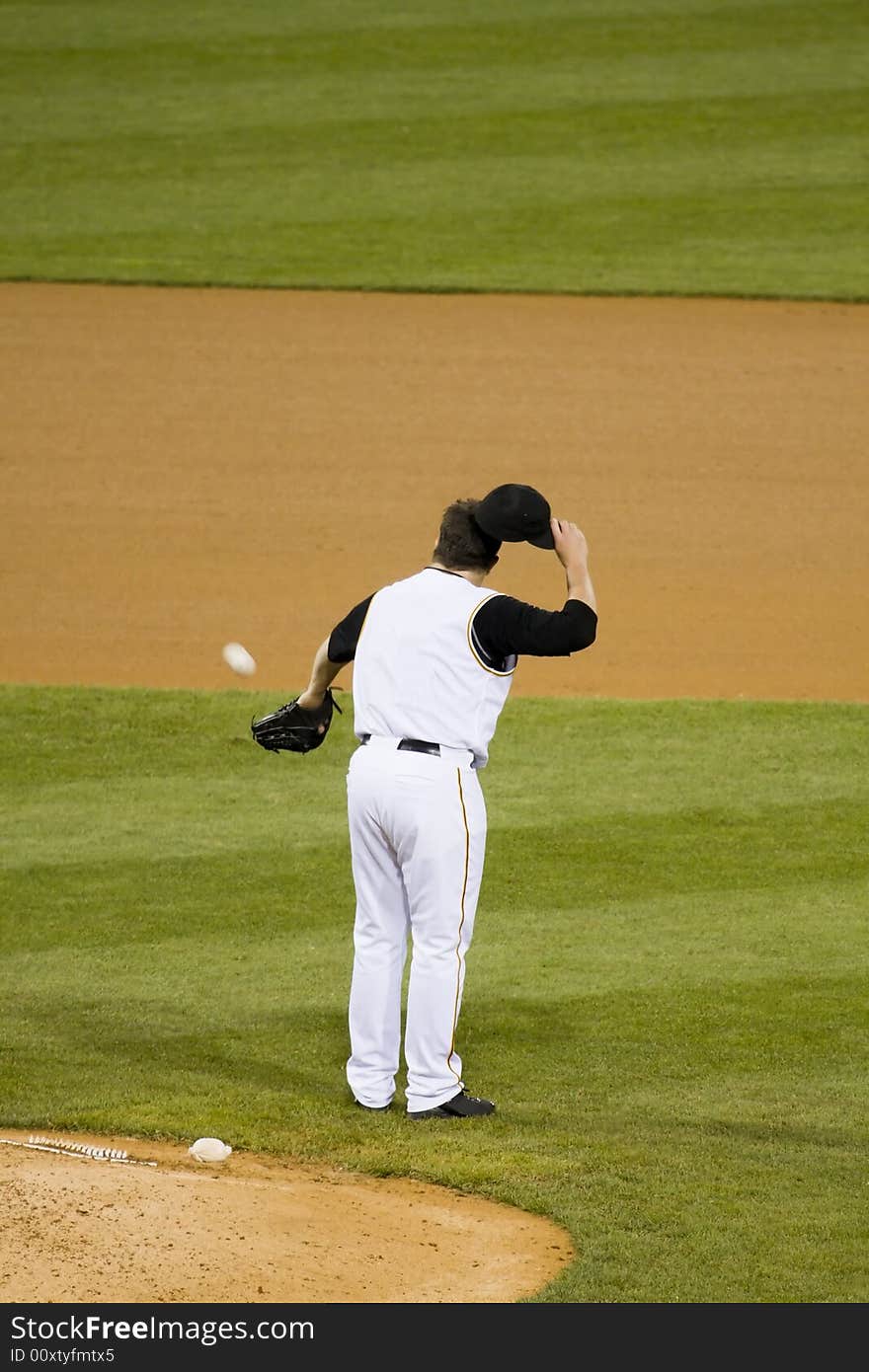 Pitcher standing still while catching a baseball. Pitcher standing still while catching a baseball