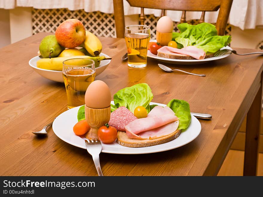 Table served with snacks. Fruits, vegetables, bread, egg, ham etc. Table served with snacks. Fruits, vegetables, bread, egg, ham etc.