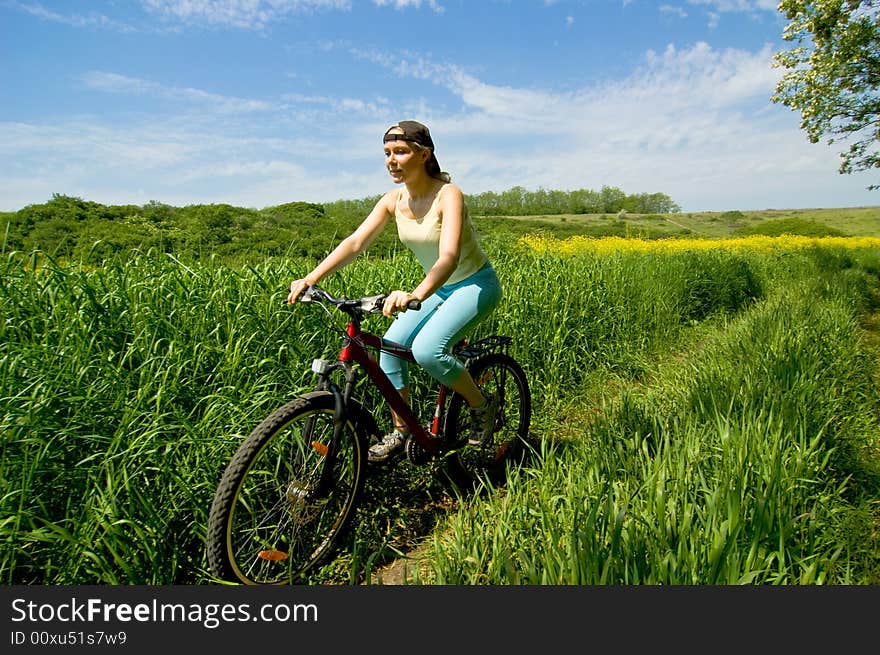 Girl biking in summer field