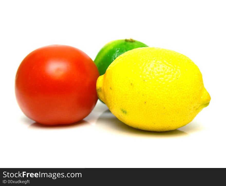 Red tomato, green lime and yellow lemon on the white background. Isolated. Shallow DOF. Red tomato, green lime and yellow lemon on the white background. Isolated. Shallow DOF.