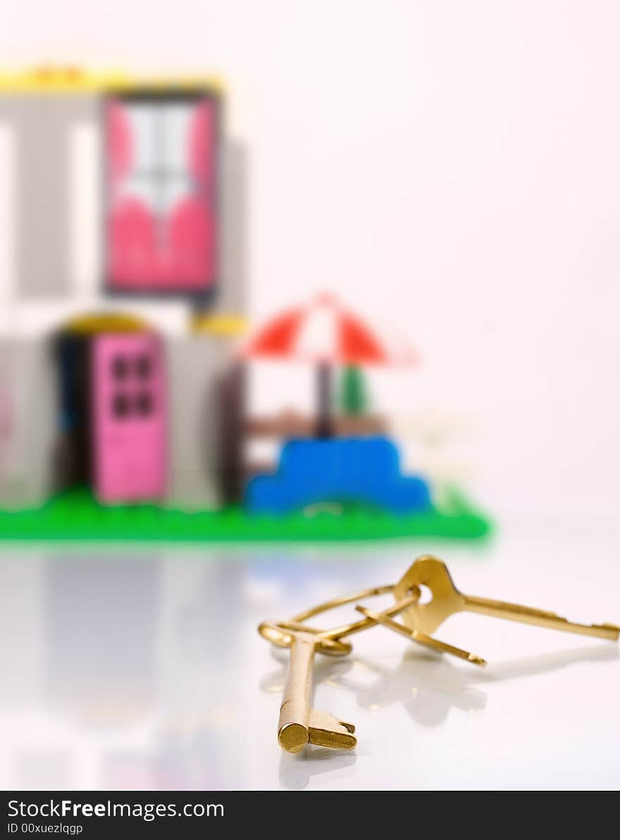 Golden key and toy house on background