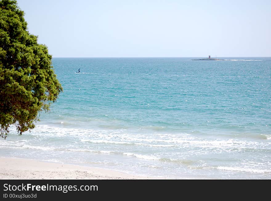 A peaceful, calm beach with a clear blue sky. A peaceful, calm beach with a clear blue sky