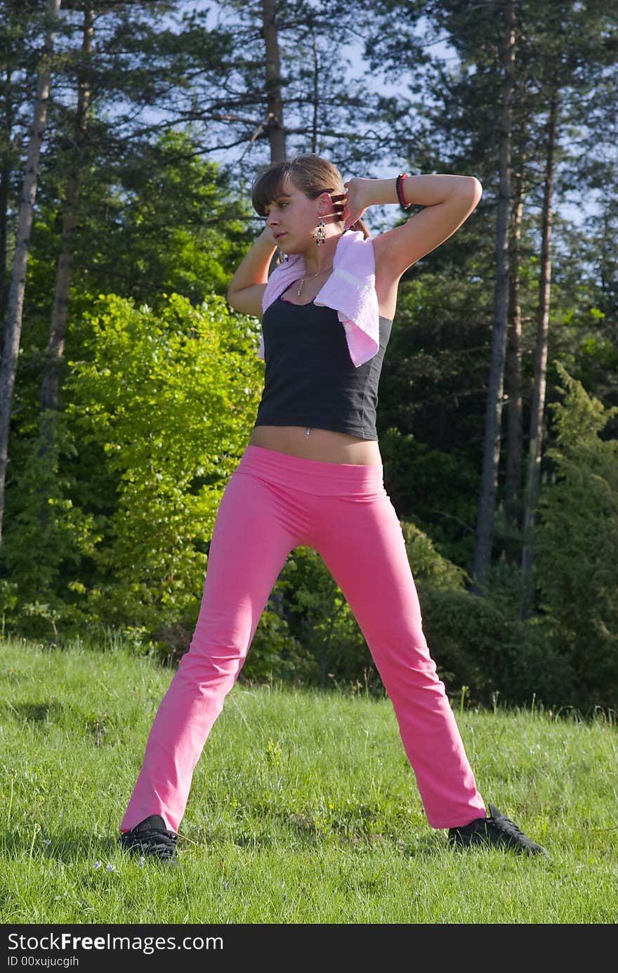 Young girl doing gymnastics in the nature with towel around neck. Young girl doing gymnastics in the nature with towel around neck