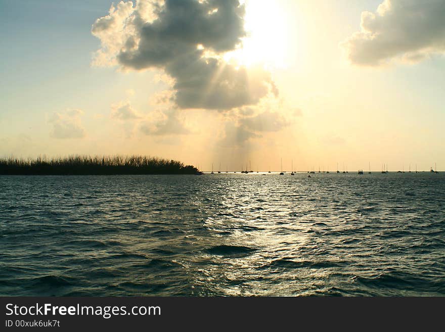 Silhouettes of boats sitting at anchor in the distance during sunset. Silhouettes of boats sitting at anchor in the distance during sunset.