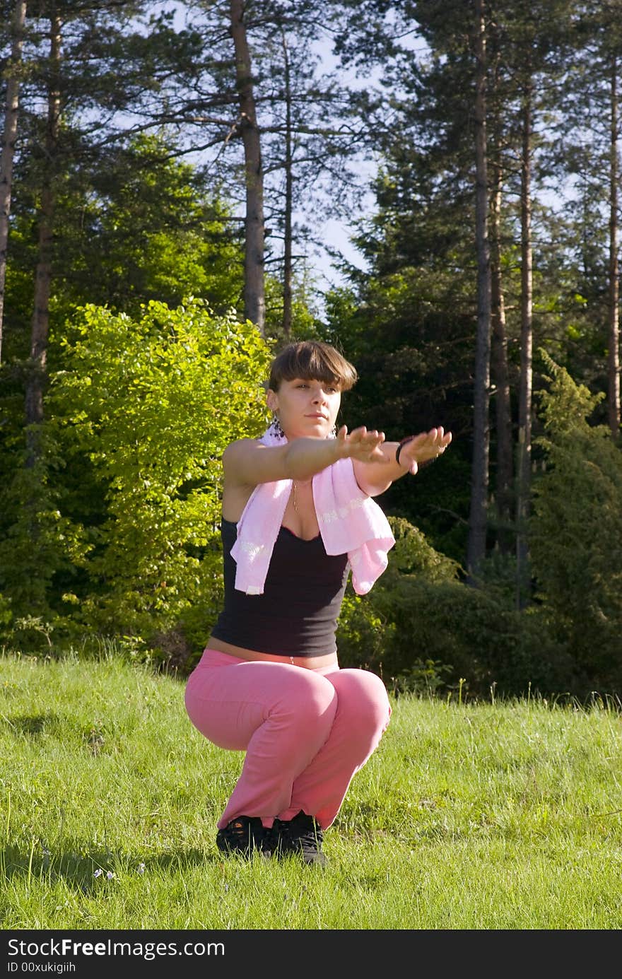 Young girl doing gymnastics in the nature with towel around neck. Young girl doing gymnastics in the nature with towel around neck