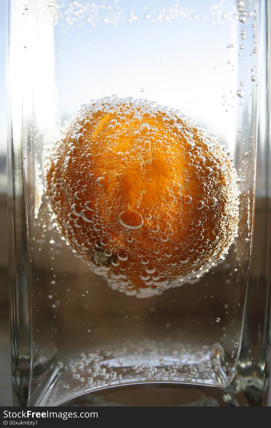 Tangerine in water with bubbles in a glass vase. Tangerine in water with bubbles in a glass vase