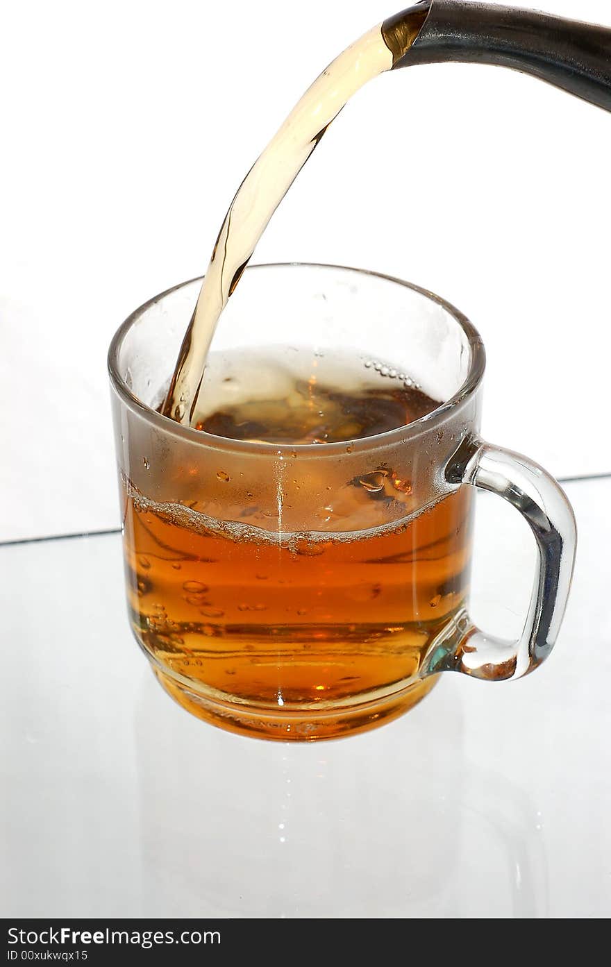 Pouring tea into glassy tea cup. Pouring tea into glassy tea cup