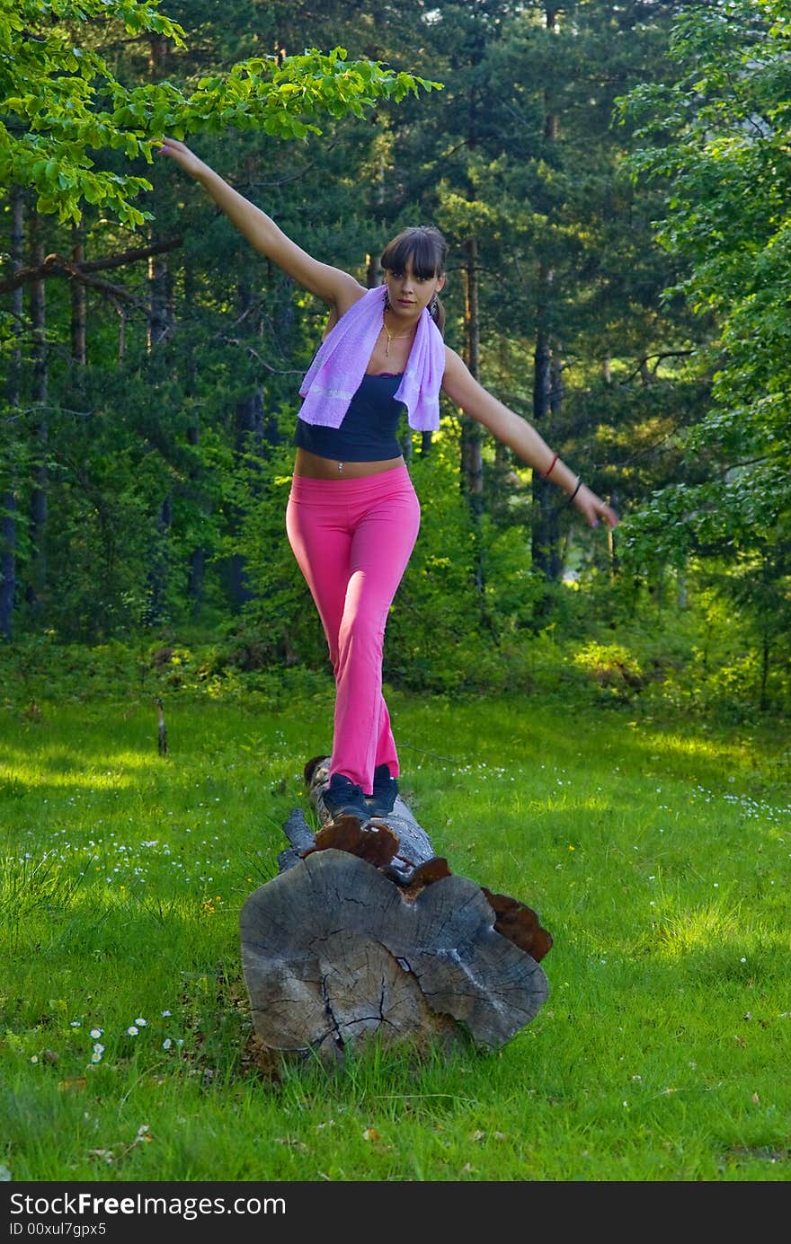 Young girl doing gymnastics in the nature with towel around neck. Young girl doing gymnastics in the nature with towel around neck